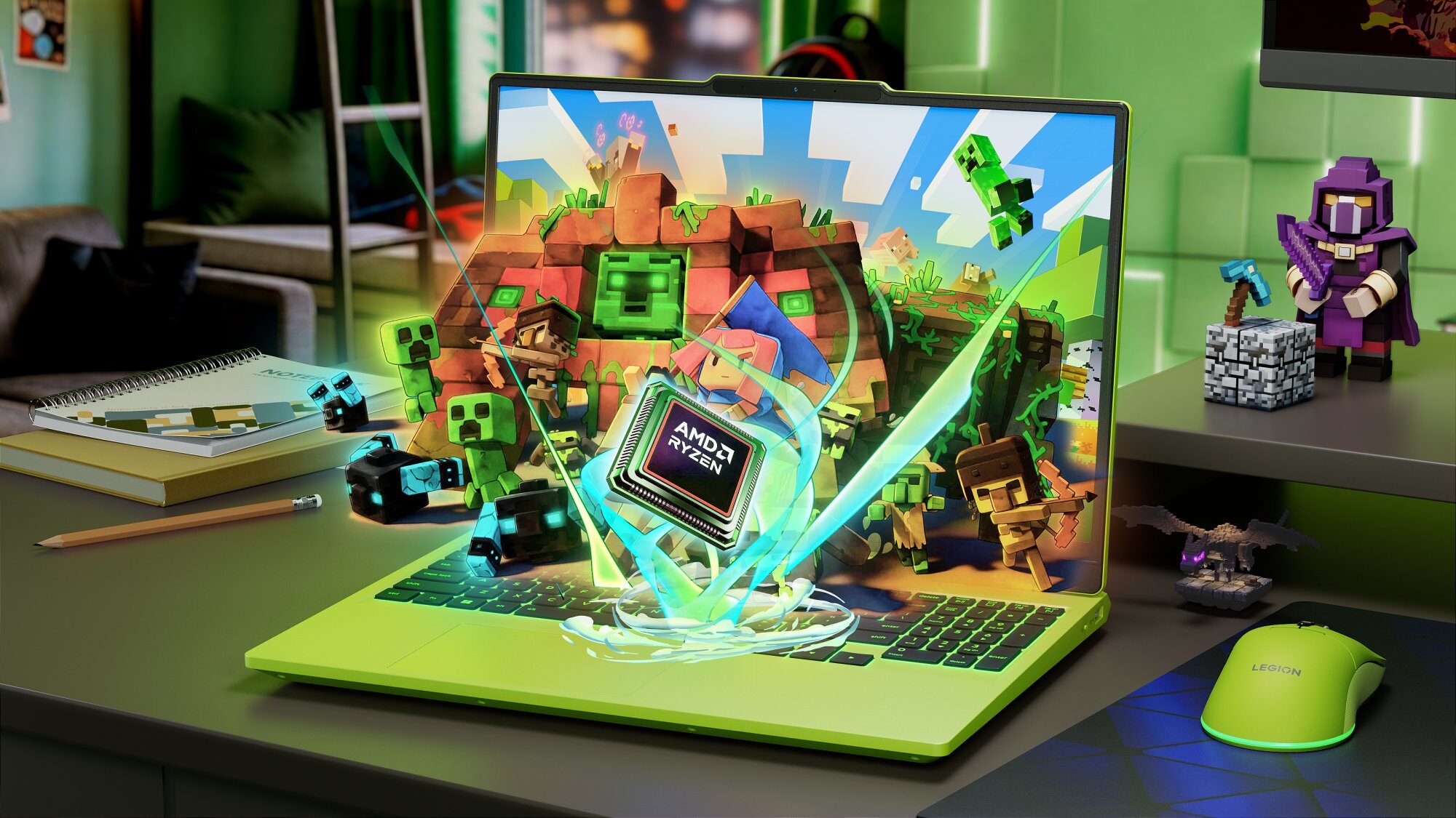Jasnozielony laptop z otwartą pokrywą, na której ekranie wyświetla się scena z gry Minecraft, a przed nim unosi się procesor AMD Ryzen; obok leżą figurki postaci z gry, myszka gamingowa i notatnik.